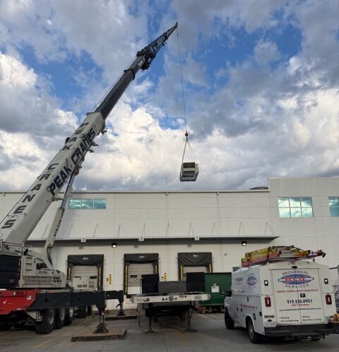 Mechanical HVAC Services technicians using a crane to replace a commercial rooftop unit in Raleigh, NC