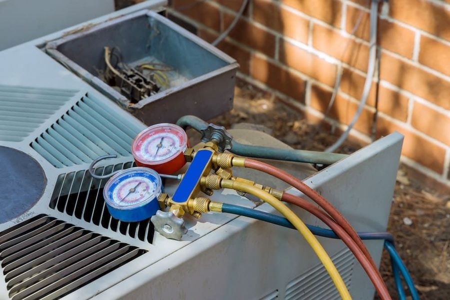 HVAC pressure gauge sitting atop an outdoor AC unit