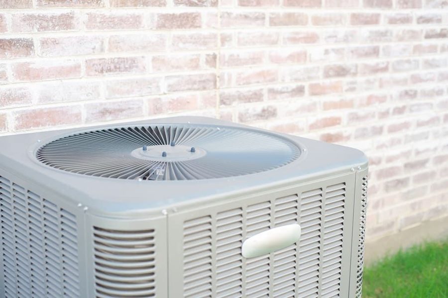 outdoor HVAC unit against a brick wall