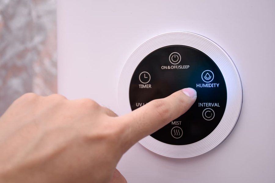 finger changing the setting on a thermostat
